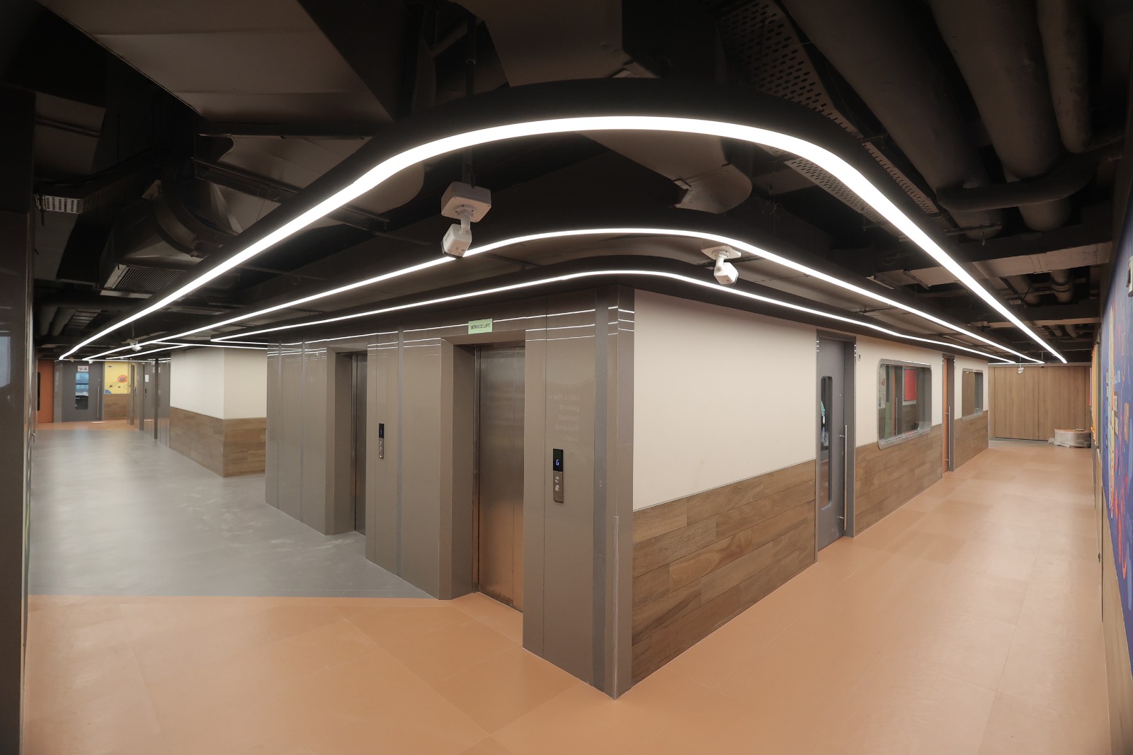 Lift lobby with curved linear lighting at Bunts Sangha School, Borivali